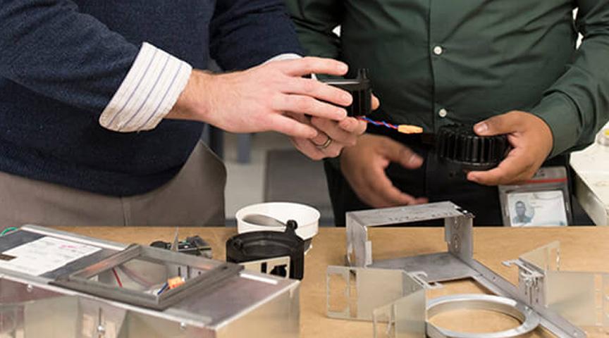 Product customization, two engineers holding custom parts in hands