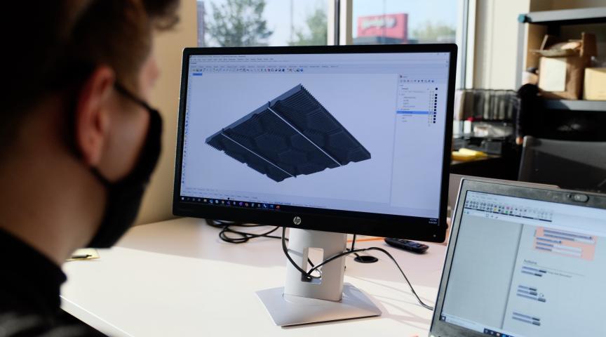 Designer looks at model on computer display