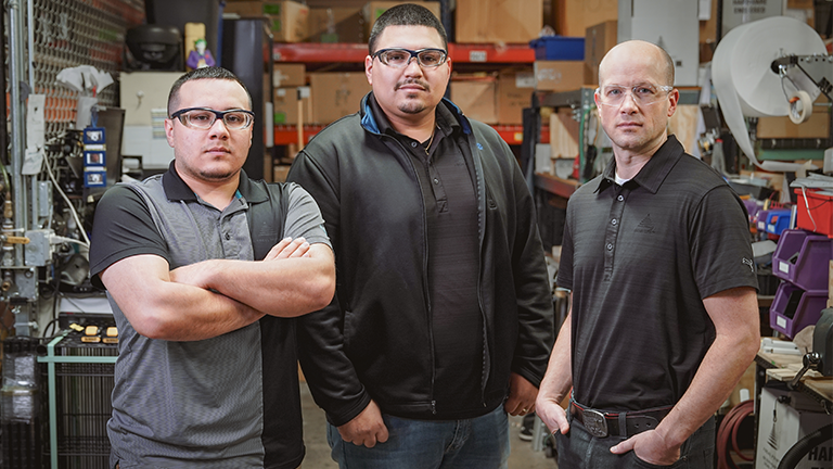 Field Service Team - 3 men posing in workshop